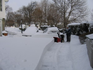 Man using snowblower to clear 16" of snow from driveway