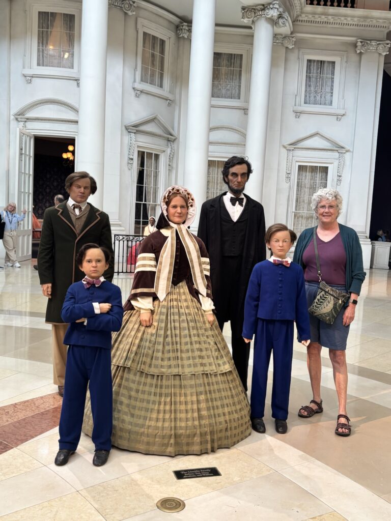 Standing with models of Lincoln's family